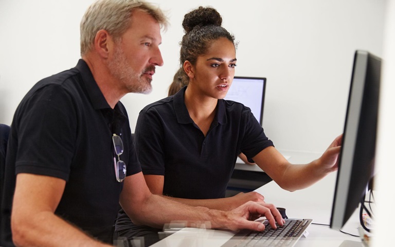 man and woman working together on a desktop computer, supporting mechanical and electrical engineering for large HVAC comapny 