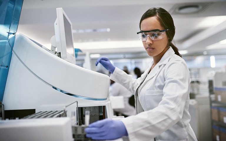 Young woman using a machine to conduct a medical test in a laboratory