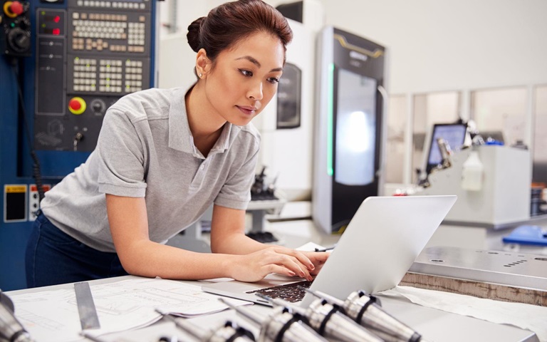 female engineer typing on laptop computer