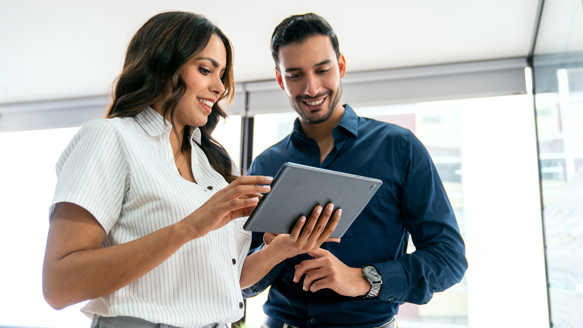 male and female excitedly reading Actalent's latest economy and labor market report for February 2025 on a tablet