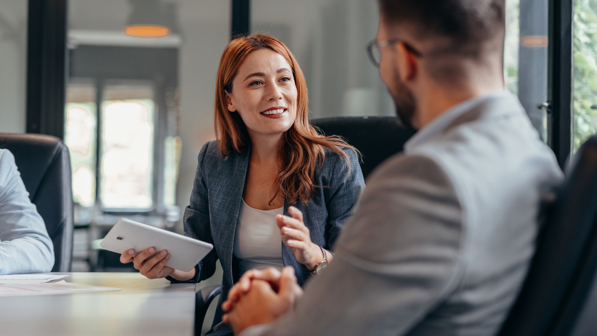 Female and male coworkers looking at labor market trends for October 2024